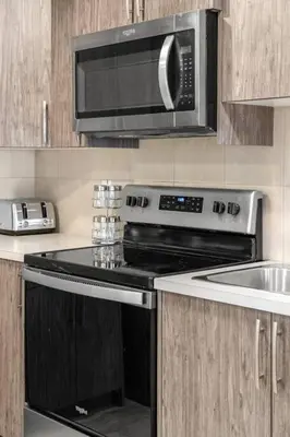 a kitchen with a stove and a microwave at Modern Basement Gem: 2 BR Retreat in Calgary