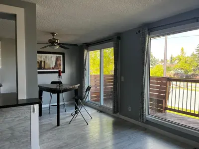 a dining room with sliding glass doors and a table at Grie hunting quite room! in Calgary