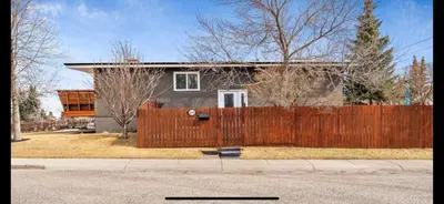 a house with a wooden fence in front of it at Grie hunting quite room! in Calgary