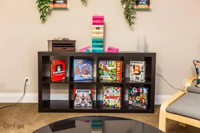 a book shelf filled with books in a living room at Cozy 3BD w/AC, Patio, Theatre Room, 15 min to DT in Edmonton
