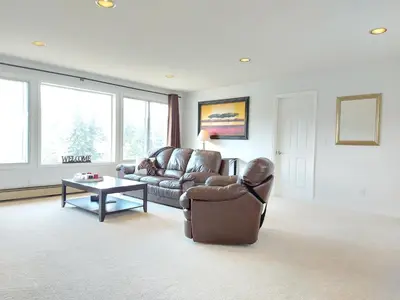 a living room with a couch and a table at Tranquil Retreat Spacious 2-Bedroom on the 2nd Floor in Kelowna