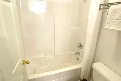 a white bathroom with a tub and a shower at Super 8 by Wyndham Sicamous in Sicamous