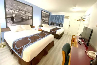 a hotel room with two beds and a desk at Super 8 by Wyndham Sicamous in Sicamous