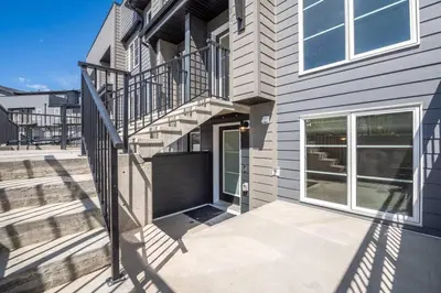 a house with a staircase next to a building at Rockland Oasis: 1BR + Parking in Calgary
