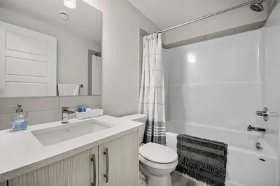 a bathroom with a sink and a toilet and a tub at Rockland Oasis: 1BR + Parking in Calgary