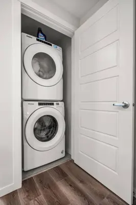 a laundry room with a washing machine and a washer at Rockland Oasis: 1BR + Parking in Calgary