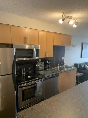 a kitchen with a stainless steel stove and microwave at Chris's Cozy Condo Times Square Rogers Place Edmonton in Edmonton