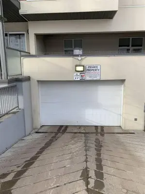 a white garage door with a sign on it at Chris's Cozy Condo Times Square Rogers Place Edmonton in Edmonton