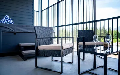 a balcony with two chairs and a table with wine glasses at Prime Revy Penthouse in Revelstoke