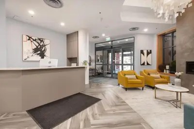 an office lobby with a reception counter and yellow chairs at Bright Whistler Village Getaway w/ pool & hot tub in Whistler
