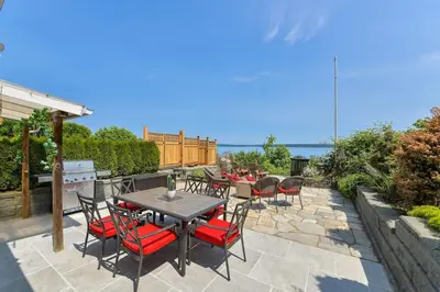 a patio with a table and chairs and the ocean at Gulf Island View Suite by EMR Vacation Rentals in Chemainus