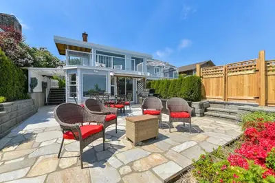 a patio with chairs and a table in front of a house at Gulf Island View Suite by EMR Vacation Rentals in Chemainus