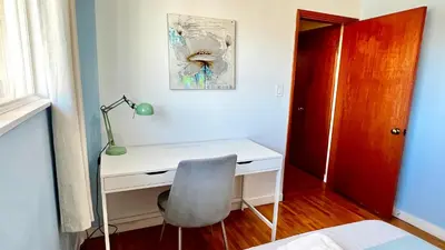 a desk with a lamp and a chair in a room at Spacious home 15mins to Downtown in Vancouver