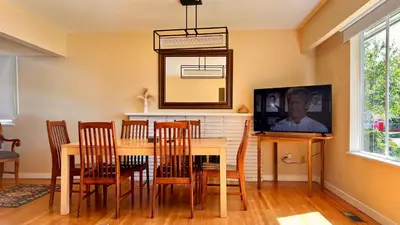 a dining room with a table and chairs and a tv at Spacious home 15mins to Downtown in Vancouver