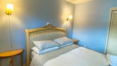a bedroom with a bed with white sheets and pillows at Spacious home 15mins to Downtown in Vancouver