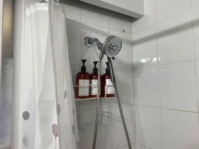 a shower with wine bottles on a shelf in a bathroom at Spacious home 15mins to Downtown in Vancouver