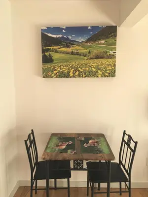 a dining room table with two chairs and a painting on the wall at The Blue Cottage B&B in Seventy Mile