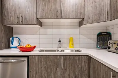 a kitchen with a sink and a bowl of fruit at Luxurious Comfortable Suite in Airdrie