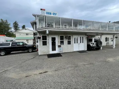 a truck parked in front of a small building at Fraser Bridge Inn in Quesnel