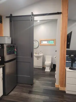 a bathroom with a sliding door and a toilet at Wells Gray Stay And Play in Clearwater