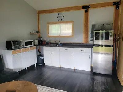 a kitchen with white cabinets and a refrigerator at Wells Gray Stay And Play in Clearwater