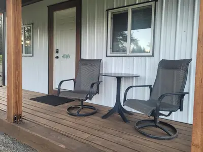 two chairs and a table on the porch of a house at Wells Gray Stay And Play in Clearwater