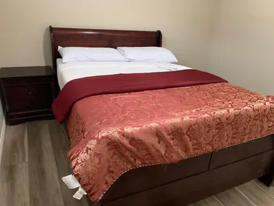 a bed with a red blanket and white pillows at Divine Homes in Calgary