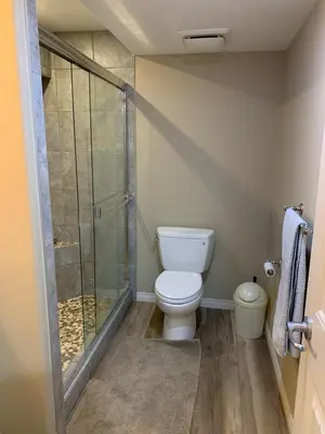 a bathroom with a toilet and a glass shower at Divine Homes in Calgary