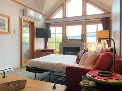 a bedroom with a bed and a couch and a fireplace at Glacier Lodge Steps to Trails and Nature in Whistler