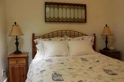 a bedroom with a large bed with two lamps at Thistle Dew Cottage in Ganges