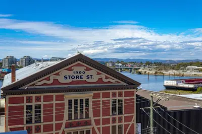 a red building with a store sign on top of it at Be Close To Chinatown When You Are In The Ironwork Building in Victoria