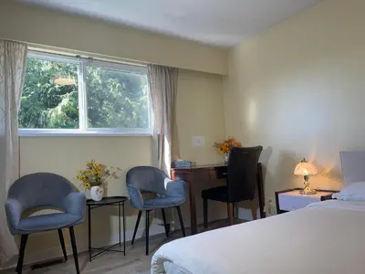 a hotel room with a bed and two chairs and a desk at New Master room & private washroom 203 in Richmond