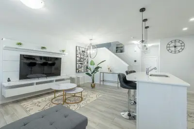 a white living room with a couch and a table at 3bedroom Stylish Getaway by the Park with 2-Car Garage in Calgary