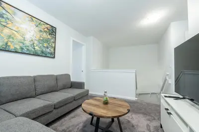 a living room with a couch and a table at 3bedroom Stylish Getaway by the Park with 2-Car Garage in Calgary