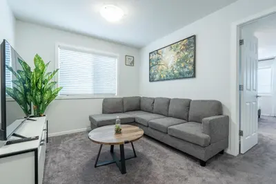 a living room with a couch and a table at 3bedroom Stylish Getaway by the Park with 2-Car Garage in Calgary