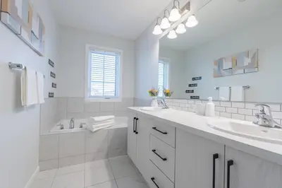 a white bathroom with a tub and a sink at 3bedroom Stylish Getaway by the Park with 2-Car Garage in Calgary