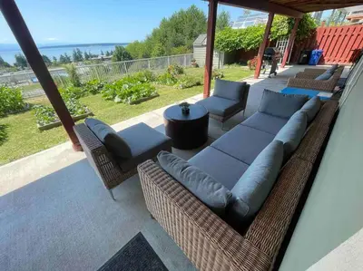 a patio with a couch and chairs and a table at Four Seasons Private Villa in Powell River