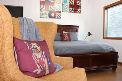 a chair with a dog pillow in a bedroom at Private Bright Modern Studio! Queen bed ! in Victoria