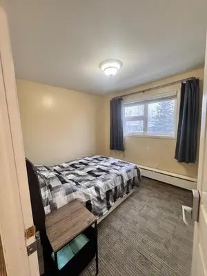 a small bedroom with a bed and a window at Discovery Suite in Yellowknife