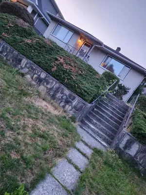 a house with stairs in front of a house at Economical Homestay hostel in Burnaby