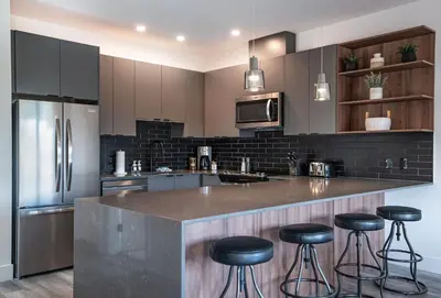 a kitchen with a large counter with stools in it at Stoke House by Revelstoke Vacations in Revelstoke