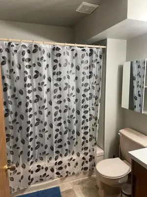 a bathroom with a black and white shower curtain at One Bedroom Main floor Apartment in Camrose