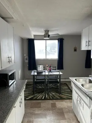 a kitchen with a table in the middle of it at One Bedroom Main floor Apartment in Camrose