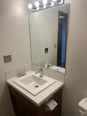 a bathroom with a sink and a large mirror at Stunning 1 Bedroom Apartment in Camrose