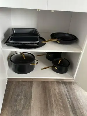 a kitchen shelf with pots and pans on it at Exquisite 2 Bedroom Apartment in Camrose