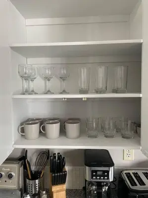 a kitchen shelf filled with glasses and wine glasses at Exquisite 2 Bedroom Apartment in Camrose