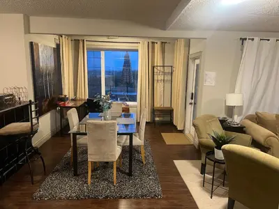 a living room with a table and a living room with a view at Private Walkout Suite with a View in Calgary