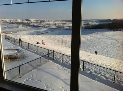 a view from a window of people skiing in the snow at Private Walkout Suite with a View in Calgary