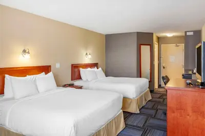 a hotel room with two beds and a bathroom at Quality Inn & Suites Edmonton International Airport in Leduc