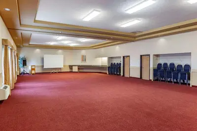 a large room with blue chairs and a whiteboard at Quality Inn & Suites Edmonton International Airport in Leduc